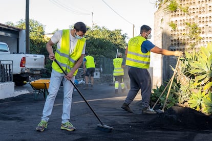 Varias personas limpian las inmediaciones de una casa, este lunes en La Palma.