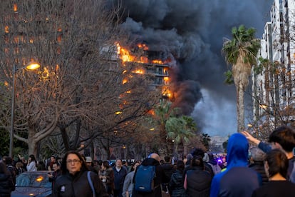  Varios vecinos observan el edificio en llamas.