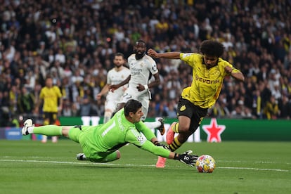 Karim Adeyemi del Dortmund salva la entrada de Courtois del Real Madrid durante el partido final de la UEFA Champions League.