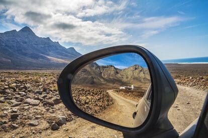 El parque natural de Jandía, en Fuerteventura, y, reflejada en el retrovisor, la Villa Winter, en Cofete.
