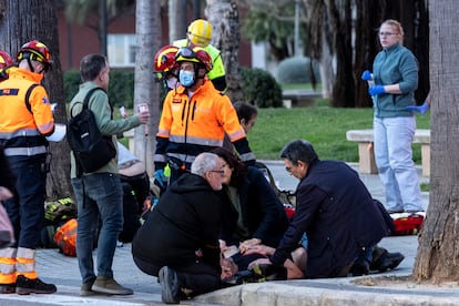 Los servicios de emergencia atienden a un vecino evacuado del edificio en llamas. 