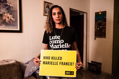 Anielle Franco sostiene un cartel con la frase "¿Quién mató a Marielle Franco?", durante una campaña de Amnistía Internacional.