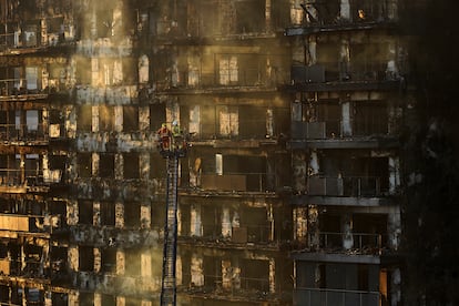 Bomberos trabajan en el edificio incendiado.