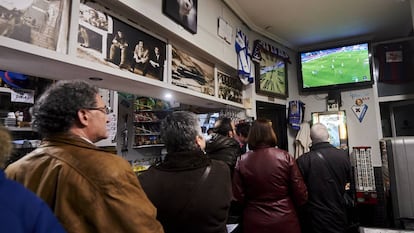Clientes de un bar siguen la emisión de un partido de fútbol.