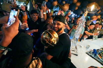 Jamal Murray, center, holds the Larry O'Brien NBA Championship Trophy after the Nuggets' victory over the Miami Heat in Game 5 of the NBA Finals.