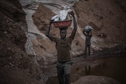 Atravesando pequeños intersticios en los laterales del cráter, con pasos lentos y descalzos, emergen hombres y mujeres con bandejas de decenas de kilos de pedruscos de granito sobre sus cabezas.