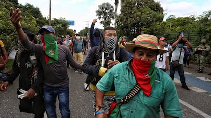 Indígenas caminham por uma rua durante uma manifestação em Cali, neste domingo. Em vídeo, o momento em que um grupo de civis armados se retira após abrir fogo contra a ‘minga’.