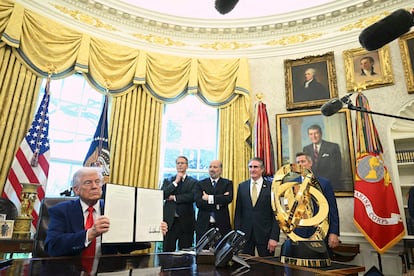 El presidente de EE UU, Donald Trump, muestra un decreto presidencial con su firma junto a algunos de sus colaboradores, el 9 de abril en la Casa Blanca.