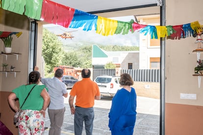 Varios vecinos contemplan el fuego desde la cochera del pueblo donde celebran la festividad del Cristo del Amparo, la más importante del municipio.