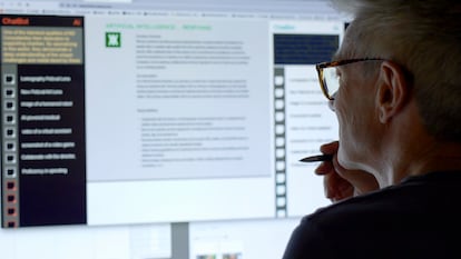 Un hombre mira una pantalla de ordenador mientras un chatbot de inteligencia artificial (IA) agrega texto.