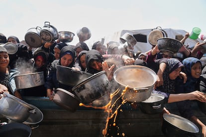 Residentes del campo de refugiados de Jan Yunis, en la franja de Gaza, se agolpan para conseguir comida.